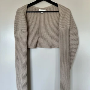 H&M bolero  - Bolero / kofta från HM i storlek M. Använd men i bra skick. Färg beige / grå. 