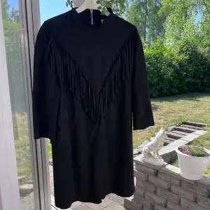 Snygg svart klänning med fransar 