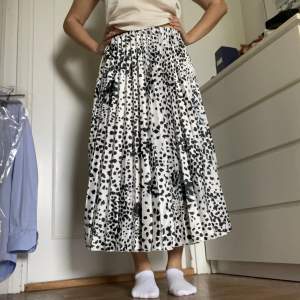 En lång plisserad kjol i vitt med svarta prickar som endast är använd 1 gång. Mycket bra skick och inga defekter. Skriv vid frågor💕