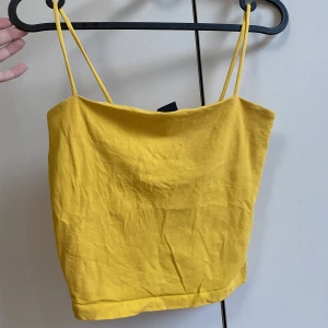 Gult linne - Ett gult linne från Gina tricot. Ser lite randig ut på första bilderna men man ser materialet på sista bilden. Skickar gärna bättre bilder vid efterfrågan. Originalpris 100kr