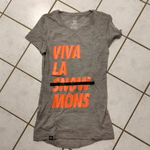 Mons royale merino - Merinullströja med tryck. Lite längre smal modell med extra längd över ryggen mer som xxs över byst och axlar. Superfin kvalitet och härlig glans i ullen. Nyskick men lappen borta.