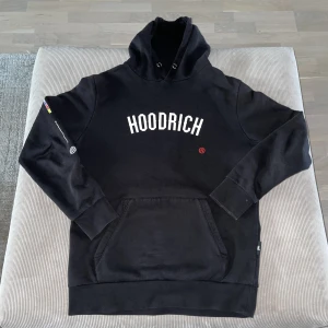 Hoodrich hoodie  - Tja, jag säljer denna feta Hoodrich Hoodien🔥Skick 9/10 då den inte har använts så mycket. Det finns inga skador eller fläckar på tröjan. Jag är 175 cm och den sitter riktigt bra på mig. Den säljs så billigt p.g.a att snörena inte finns kvar.