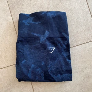 Träningstights Gymshark - Säljer dessa blå träningstights från Gymshark! Lite noppriga men det går lätt att få bort 🩶 Nypris: 599kr