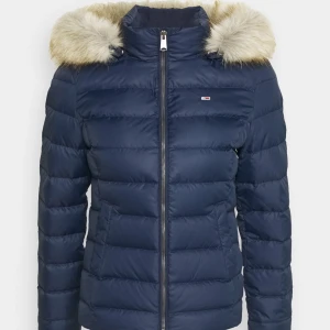 Tommy Hilfiger dunjacka  - Supersnygg och varm mörkblå dunjacka från Tommy Hilfiger. Fint skick, inga defekter! Nypris idag ca 1600 kr. Både luvan och pälsen går att ta av.