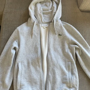 Lacoste zip - Grå lacoste zip, passar ungefär dem som är 168 cm- 178 cm. Bara skriva vid intresse eller frågor! Pris kan diskuteras