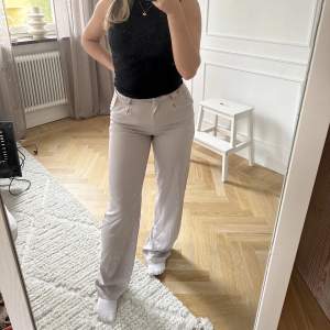 Ljusgrå randiga kostymbyxor. Midwaist storlek 36