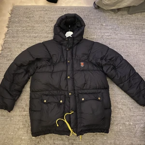 Fjärllräven jacka - Köpt här på Plick men kommer inte till användning. Den har en diskret lagning på armen. Snöret på huvan saknas