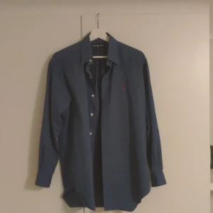 Ralph Lauren skjorta  - Hola! Säljer min Raffe skjorta eftersom den aldrig kommit till användning. Perfekt nu till hösten då den är utav tjockare material och fett grisch. Jag är 175 och den sitter utmärkt på mig. För frågor och funderingar tveka inte på att ta kontakt! Mvh
