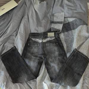 Svin snygga vintage jeans med vingar på baksidan och insydd ”kalsong” kant. Så fin grå färg. Något slitna i ändan av byxan samt fickor men ser ut som del av look. Storlek 158. Jag (34/36) får på mig dem precis. Bara att buda på dessa dröm jeans! 