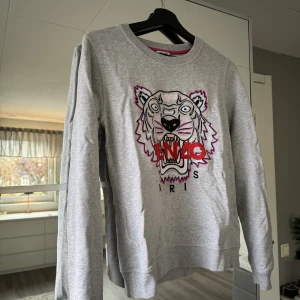 Kenzo Sweatshirt  - Säljer nu min gråa sweatshirt från Kenzo. Som passar perfekt nu när det är lite kyligare. Den är i ny skick endast använd ett fåtal gånger.  Stolek: XS Nypris: 2300kr Mitt pris: 1100kr (kan gå ned i pris vid snabb affär)