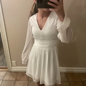 DAHLIA DRESS - En vit klänning från bubbleroom🤍 Använd en gång, och i superfint skick. Har ett band man kan knyta både fram och bak🎀 Strl 32, nypris 699. Säljer för 400+ frakt!