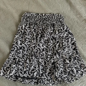 Svart/vit kjol - Svart kjol med vitt blommönster använd cirka 3 gånger. Säljer för att den inte passar längre. Från Cubus storlek 34.