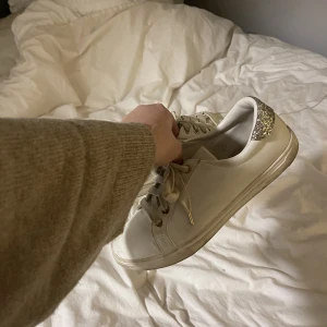 Vita sneakers  - Säljer vita sneakers i storlek 39, med en glitter kant vid hälen!! 