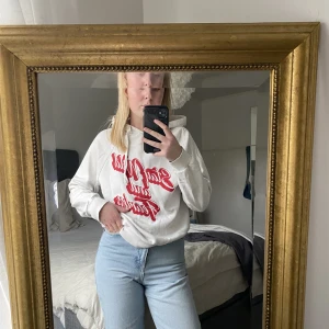 Vit hoodie med rött tryck  - En vit hoodie med rött tryck från Ginatricot . Storlek XS.