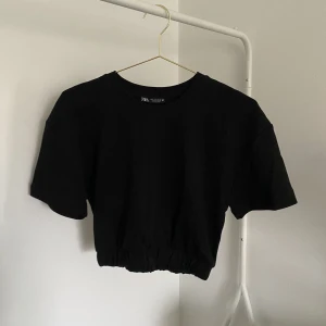 Svart croppad T-shirt  - En svart croppad T-shirt från Zara. Storlek S. 