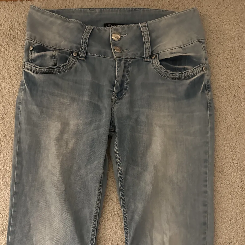 Säljer mina favorit lågmidjade jeans då dom blivit för korta. Så coola då dom har två knappar och en bred linning längst upp.🙌🏻🌟De har storleken 32 men passar också mig som vanligtvis har 36!. Jeans & Byxor.