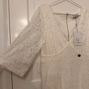 Spetsklänning  - Vit spetsklänning från Chiara Forthi Milano i storlek L. V-ringad och markerad vid byst och midja (se bild). Lösare trekvartsärmar. Endast provad, ny med lappar.