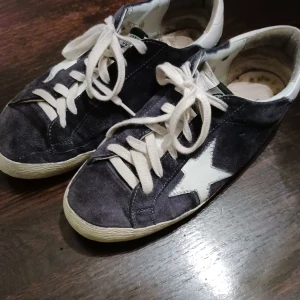 Golden Goose sneakers stl 38 - Golden goose sneakers i blå mocka, stl 38. Passar mig som ligger mellan 38-39 i stl. Enligt design ska de se slitna ut. De är använda men inte smutsiga. 