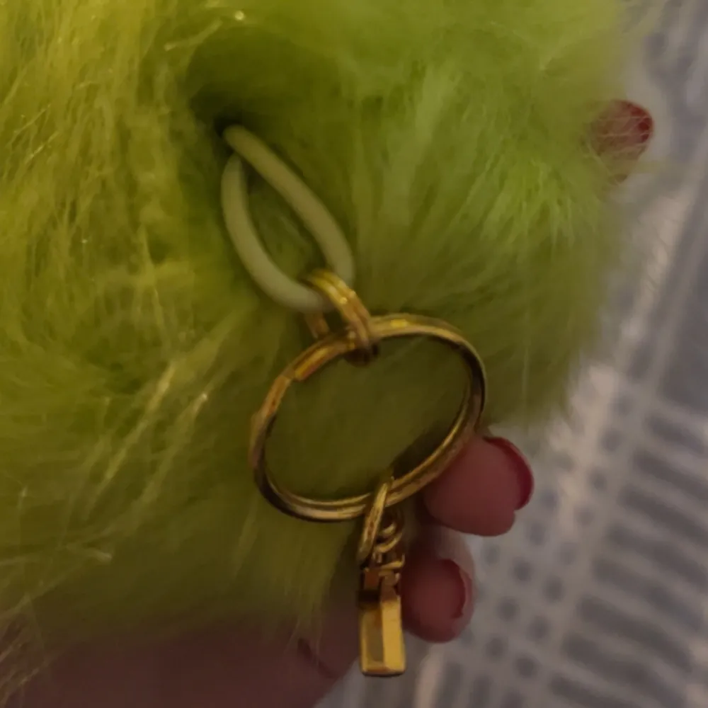 Grön pompom nyckelring. Köparen står för frakten💚. Övrigt.