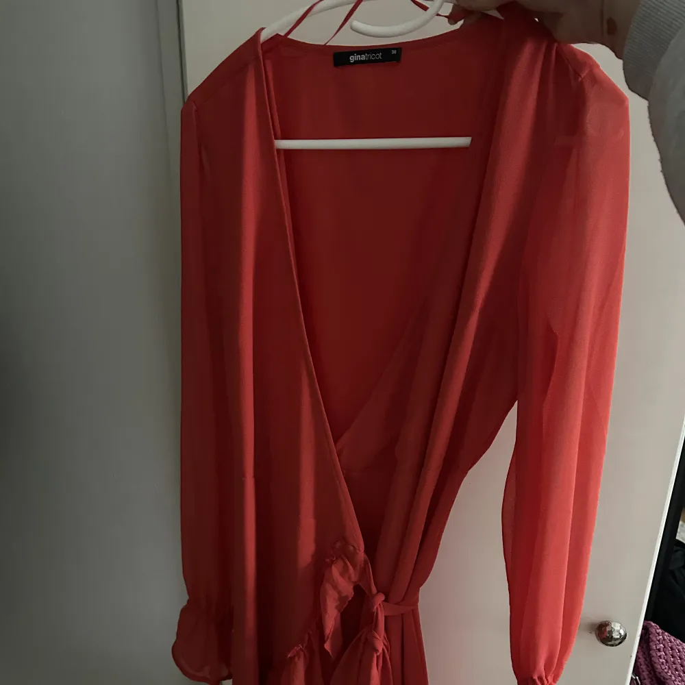En orange/röd volangklänninging från Gina i strl.38! En superfin sommarklänning, enbart använts en gång. Sälja pga att den ej kommer till användning. . Klänningar.