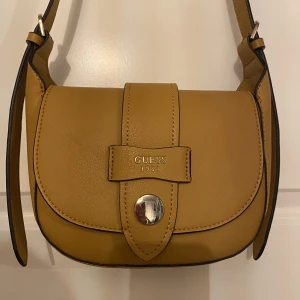 Guessväska - Äkta guessväska i senapsgul. Den är i jättefint skick.