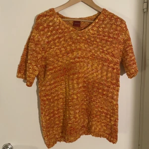 Stickad topp - En superfin stickad topp i orange tråd med inslag av röd, gul och rosa. Perfekt för en sval sommardag eller för hösten. 