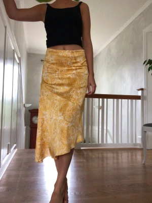 Kjol - Gul glansig kjol, osymmetrisk. Knappt använd. 