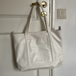 Vit stor väska - En superfin stor vit väska perfekt inför den kommande skolstarten! Den är i superbra skick då den bara har blivit använd 2-3 gånger!💕Den är väldigt rymlig. Höjd: 28cm. Längd: 38 cm.