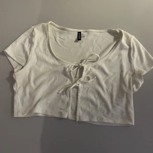 Vit topp - Vit kortärmad topp från H&M i strl L, två knyten fram. Aldrig använd då den är för kort för mig, testad 1 gång. 
