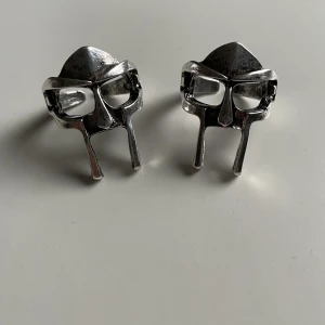 MF DOOM Ring - Säljer två stycken helt nya Mf Doom ringar💍. Båda är såklart i nyskick och kvaliten är bra. Skriv gärna om det är något du undrar, 100kr styck, går att pruta!💙