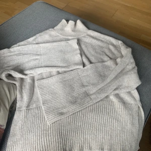 Stickad tröja Gina Tricot  - Stickad tröja från Gina Tricot ljus beige med slits på sidorna o vidare ärmar stl M Använd 1 gång