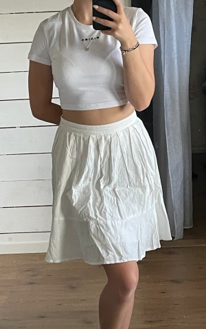 Kjol - Vit mellanlång kjol av lätt material Aldrig använd  34 cm i midjan, ej stretchig Stryks innan den skickas om så önskas 