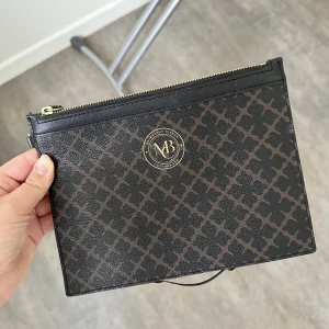 By Malene Birger Clutch - Brun clutch från By Malene Birger. Har lossnat lite på undersidan, går att klippa av så syns det knappt. 200 kr exkl frakt. 