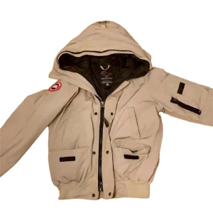 Canada goose bomberjacka - (Kopia, därav pris) Storlek XS men passar en S också. Kom chatt för fler bilder på muddarna, dragkedja, luva, osv. Päls finns ej. Supervarm och skön jacka. Använd 1 vinter. Säljer för att jag har för många vinterjackor och behöver rensa