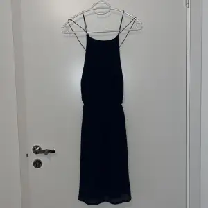 Superfin klänning med svinsnygg rygg i marinblå färg. Resår i midjan. Använd endast fåtal gånger
