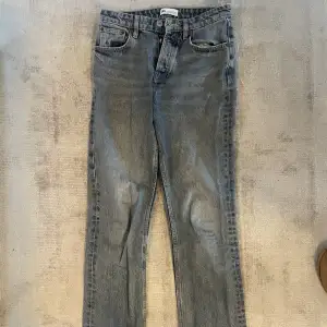 Zara jeans i midrise straight i en gråblå färg. Dem har blivit slitna längst ner på baksidan av jeansen. 