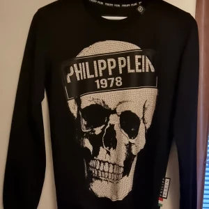 ÄKTA PHILIPP PLEIN ÄKTA PHILIPP PLEIN STRL S - ÄKTA PHILIPP PLEIN STRL S Äkta Philipp Plein, tyvärr inga kvitton   Du kan testa scanna QR koden! Lite använd inga fläckar.   Svart Strll S Äkta Långärmad