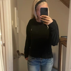 Polo tröja - En svart polo tröja i fint skick. Med en slits längst ner på sidorna av tröjan.