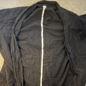 Svart japansk haori - kortärmad och skulle funka bra till typ en cosplay. funkar som normala kläder också. M men är lite tight så funkar som S också! Har katt i hemmet