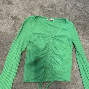 En grön tröja som går att justera, från NEW YORKER i storlek XS