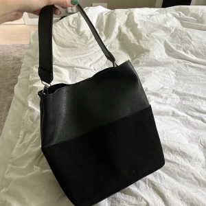Svart handväska - Säljer denna jättefina handväska från Åhléns. Många fack i väskan samt några fack utanpå väskan. Både skinn och mocka material. Pris: 200+frakt🥰
