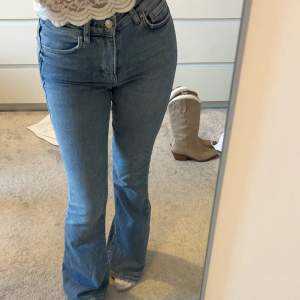 Blåa jeans med bootcut och hög midja från Gina Tricot i storlek XS. Jeansen har använts vid något enstaka tillfälle och är därav i nyskick. 