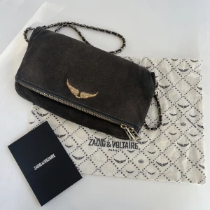 Zadig Voltaire Väska  - Säljer denna assnygga grå/svarta mocka väska från Zadig Voltaire. Den är äkta och både kvitto och dustbag ingår. Jag tror storleken är den mellersta. Väskan är använd men i gott skick. Skriv gärna privat vid frågor eller mått etc. 💕💕 