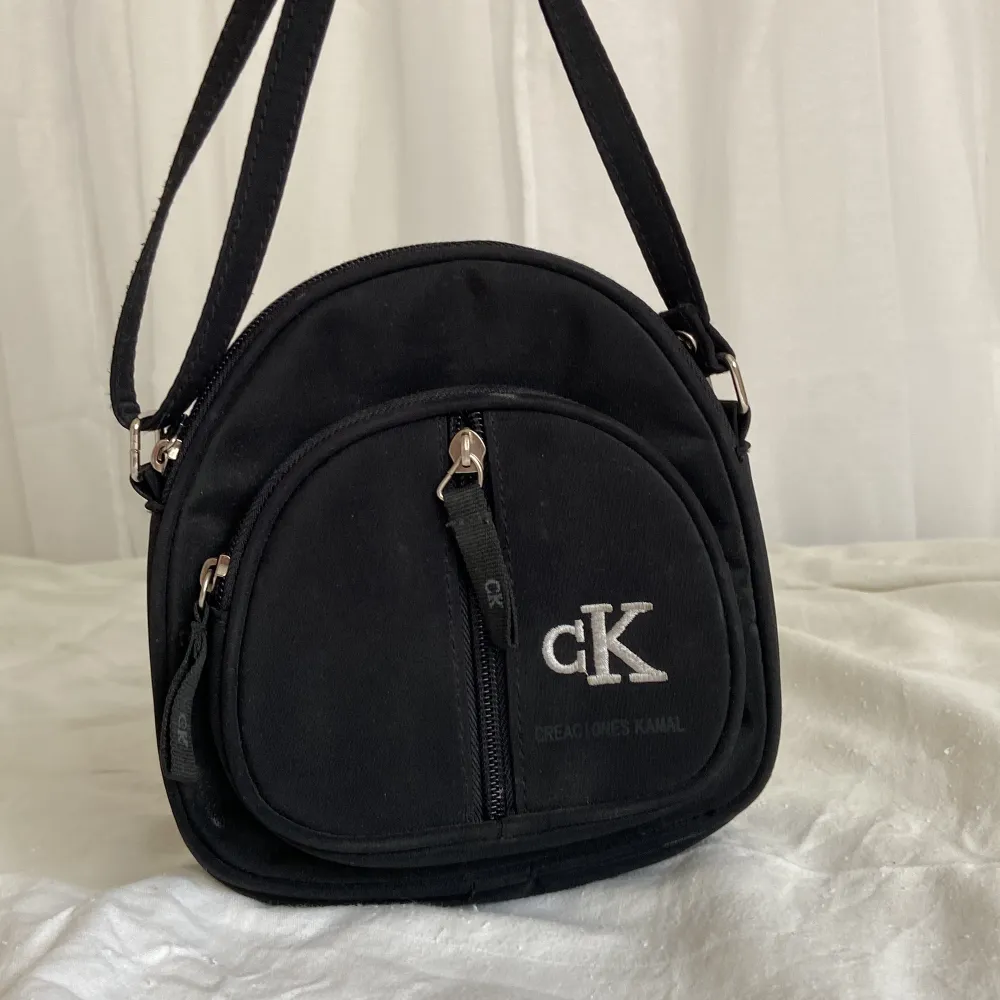 En mindre svart väska av märket ”creaciones Kamal” med totalt 3 stycken fack i olika storlekar. Bandet går att ställa ☺️🌸 80kr + frakt :) . Väskor.
