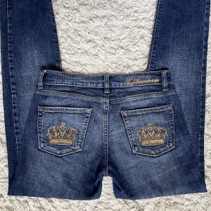 Lågmidjade Victoria Beckham Jeans - Säljer dessa skitsnygga Victoria Beckham jeans då de tyvärr är smått försmå för mig. ❤️ Vet ej storlek men midjemåttet är 35cm och innerbenslängden är 79cm. De är i perfekt skick förutom att några rhinestones saknas från kronorna. Köpare står för frakt! 🫶