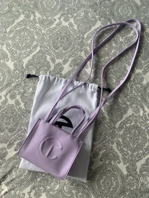 Telfar small lavender  - Telfar handväska i storlek small. Färg lavendel Använd endast 1 gång, som nyskick. Inga hål, fläckar eller fel på sömmar.  Dustbag medföljer.