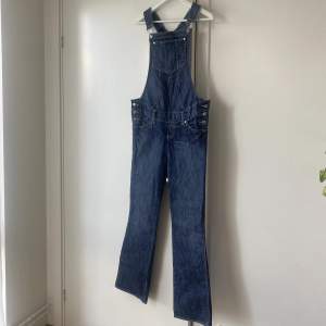 Hängselbyxor med byxa i bootcut-modell. Köpt i vintagebutik, vintage H&M. Storleken är M, men jag som vanligtvis är strl S har bärt dom oversized.