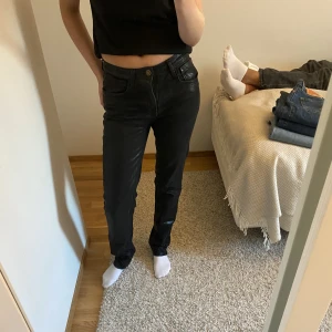 Glansiga jeans - Svarta glansiga jeans. Köparen står för frakten. De är stretchiga och lite större i storleken så även om de är storlek 32 passar de mig som brukar ha 36. Skriv för fler bilder. 