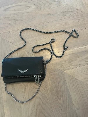 Zadig & Voltaire väska  - Denna Zadig & Voltaire väskan har inga hål eller märken! Den är äkta och jätte fin. jag har extra skinn biten kvar om den skulle få hål som man får med.