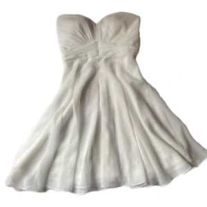 Creme vit klänning - vit strapless klänning köpt i London, inte genomskinlig eller för kall eftersom den har dubbla tyg. (Dragkedja på sidan som är en aning trög) och jättefina glittriga paljett detaljer vid kedjan. Inga fläckar eller andra defekter, den är nästan oanvänd❣️❣️